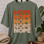 Socially selective graphic T-shirt featuring the word “NOPE” repeated five times in retro stacked lettering, a bold refusal humor shirt for plan avoiders, low social battery days, and people who prefer opting out.