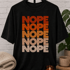 Socially selective graphic T-shirt featuring the word “NOPE” repeated five times in retro stacked lettering, a bold refusal humor shirt for plan avoiders, low social battery days, and people who prefer opting out.
