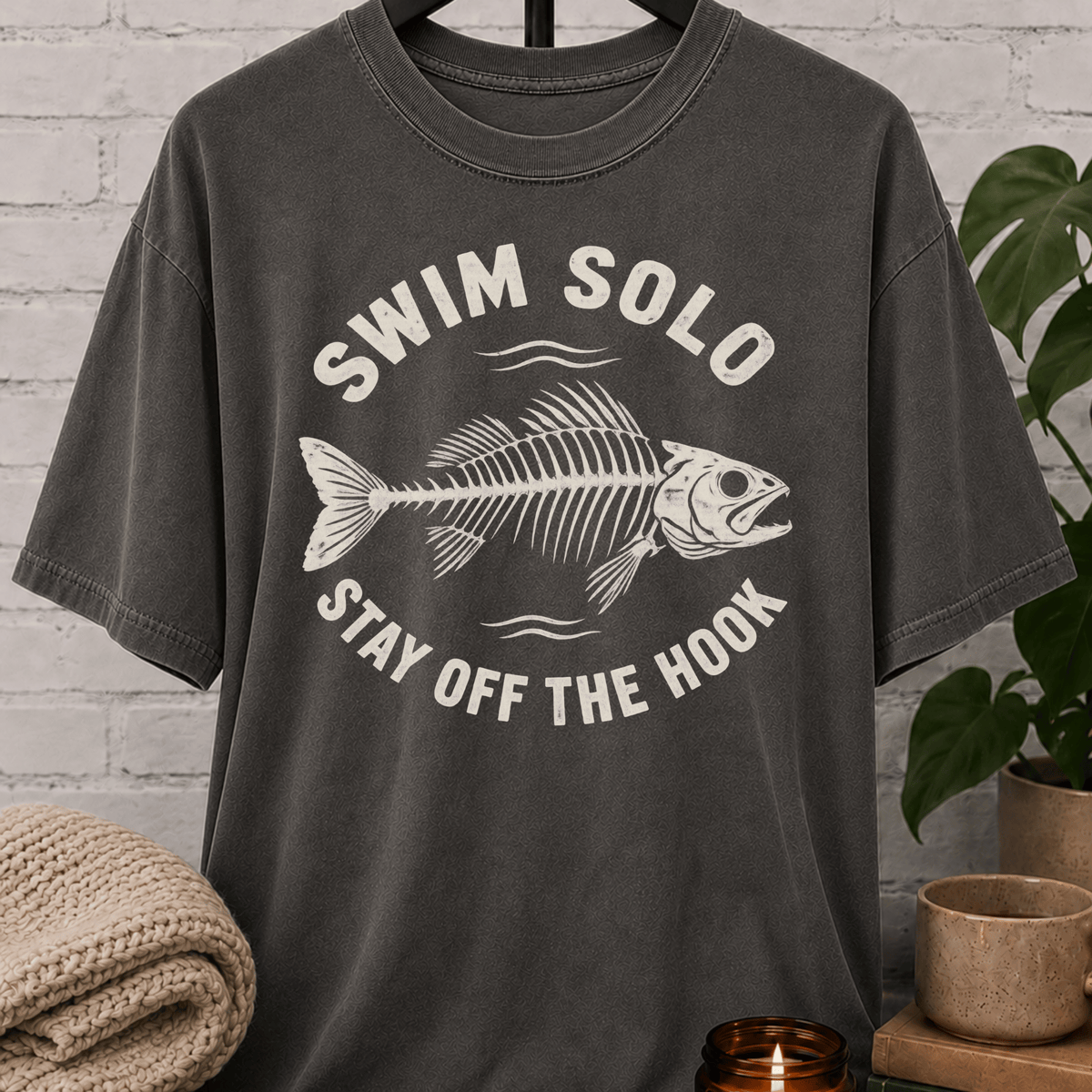 Loner fish graphic T-shirt featuring a fish skeleton with the phrase “Swim Solo Stay Off the Hook,” a sarcastic solo-life shirt for independent people, solitude lovers, and fans of people-avoidance humor.