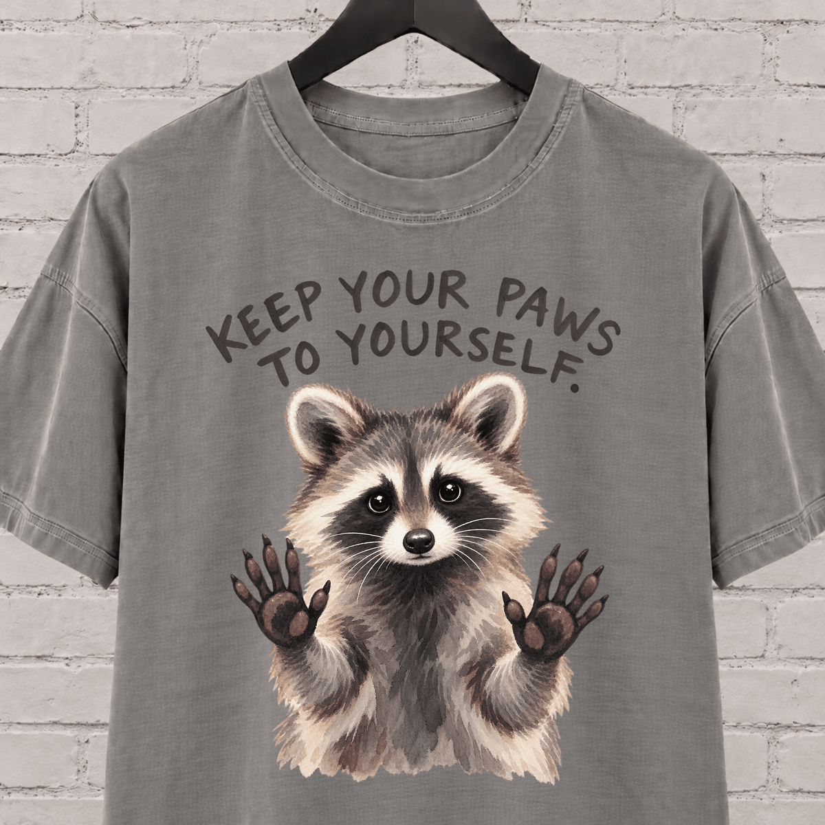 Keep Your Paws to Yourself raccoon graphic T-shirt featuring a raccoon with raised paws, an antisocial personal space shirt.