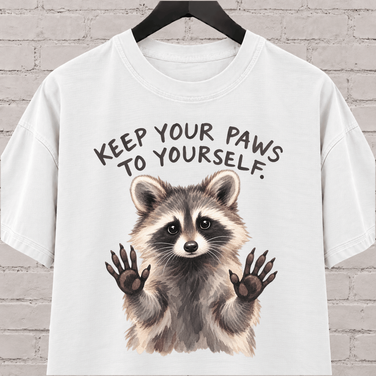 Keep Your Paws to Yourself raccoon graphic T-shirt featuring a raccoon with raised paws, an antisocial personal space shirt.