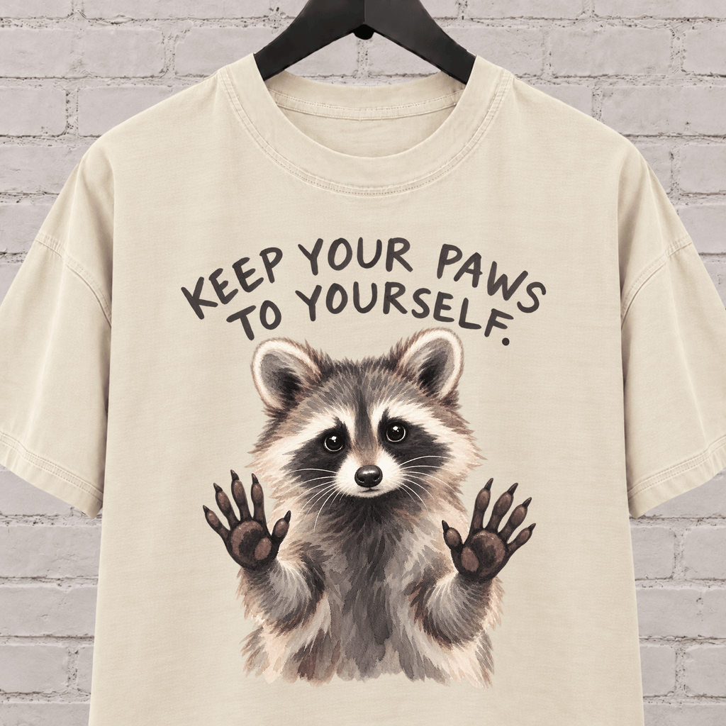 Keep Your Paws to Yourself raccoon graphic T-shirt featuring a raccoon with raised paws, an antisocial personal space shirt.