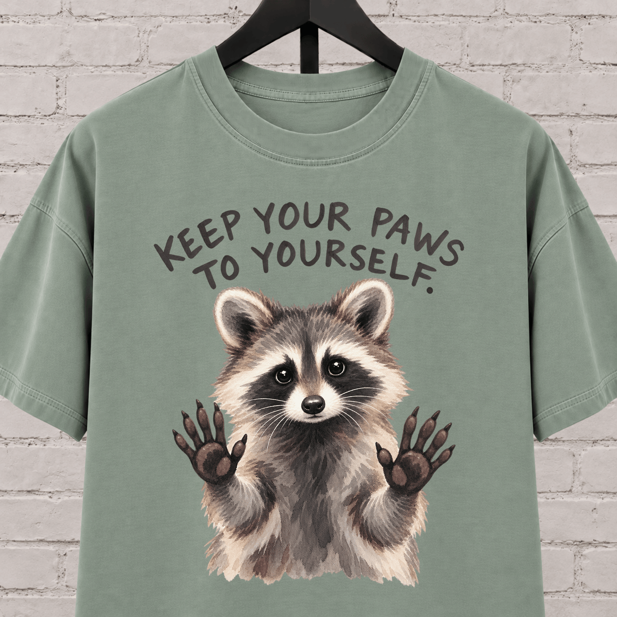 Keep Your Paws to Yourself raccoon graphic T-shirt featuring a raccoon with raised paws, an antisocial personal space shirt.