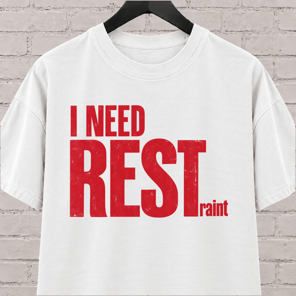 I Need Restraint graphic T-shirt featuring bold distressed lettering, an overwhelmed and overstimulated humor shirt for people who seriously need rest.