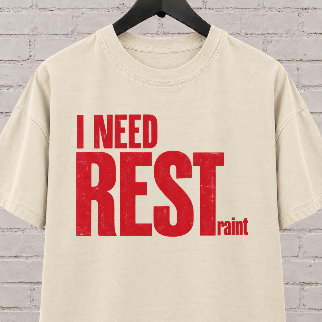 I Need Restraint graphic T-shirt featuring bold distressed lettering, an overwhelmed and overstimulated humor shirt for people who seriously need rest.
