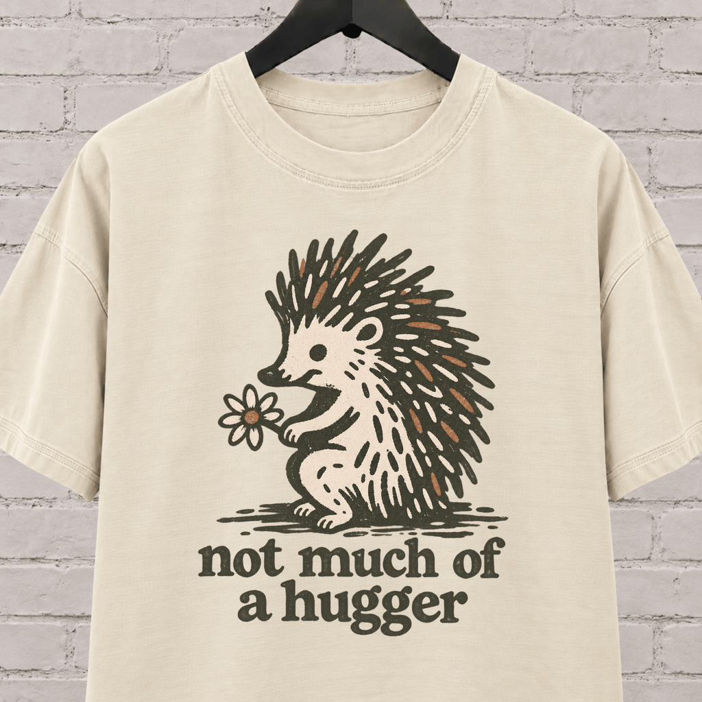 Not Much of a Hugger hedgehog T-shirt featuring a hedgehog holding a flower, an introvert personal space graphic tee.
