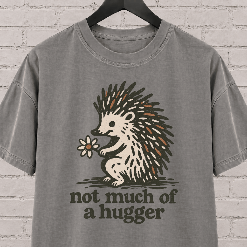 Not Much of a Hugger hedgehog T-shirt featuring a hedgehog holding a flower, an introvert personal space graphic tee.