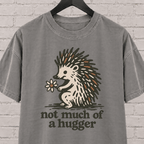 Not Much of a Hugger hedgehog T-shirt featuring a hedgehog holding a flower, an introvert personal space graphic tee.