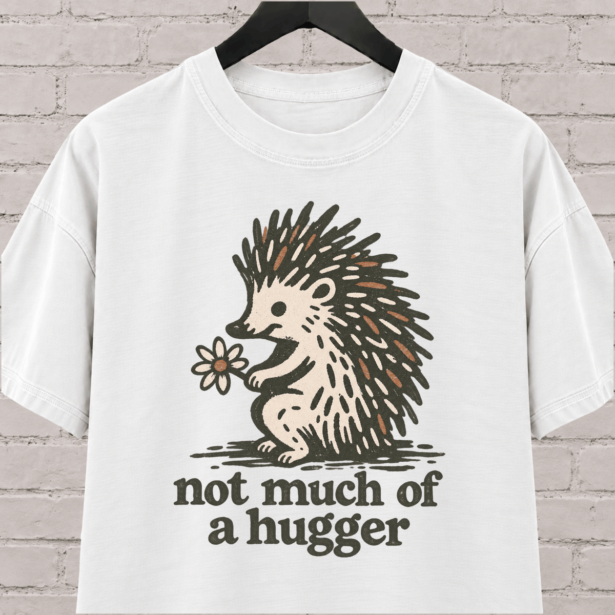 Not Much of a Hugger hedgehog T-shirt featuring a hedgehog holding a flower, an introvert personal space graphic tee.