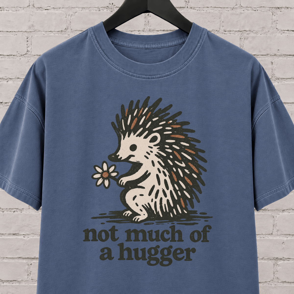 Not Much of a Hugger hedgehog T-shirt featuring a hedgehog holding a flower, an introvert personal space graphic tee.