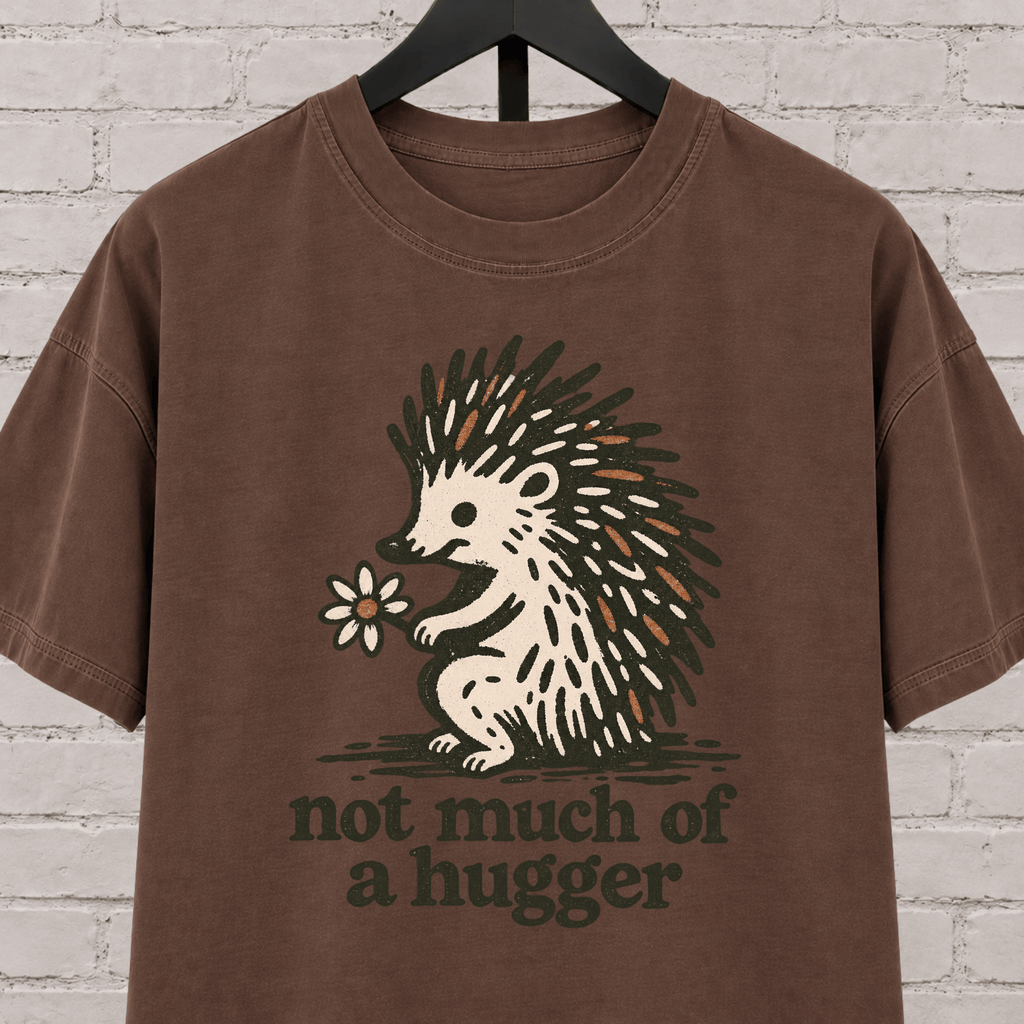 Not Much of a Hugger hedgehog T-shirt featuring a hedgehog holding a flower, an introvert personal space graphic tee.