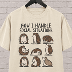 Socially awkward hedgehog graphic T-shirt featuring nine illustrated hedgehogs in different poses with the phrase “How I Handle Social Situations.”